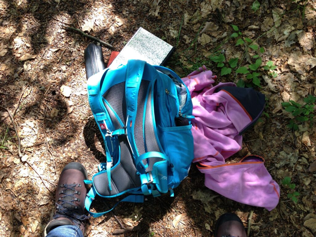Utensilien zum Wandern und Schreiben: Rucksack, Wanderschuhe, Schreibblock, leichte Jacke, Stift