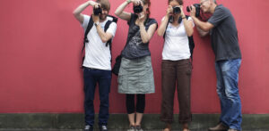 Bloggerinnen und Blogger fotografieren vor einer roten Wand